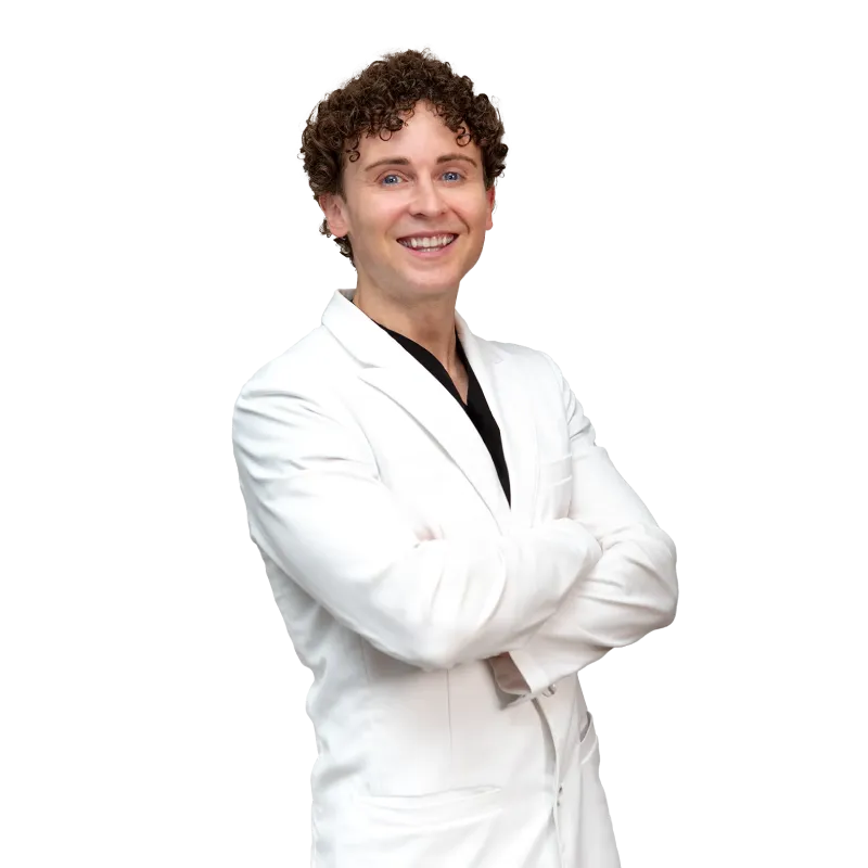 Dr. Shane Volney, board-certified physician at Vein Treatment Clinic, wearing a white coat and smiling confidently