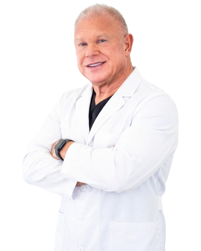 DrStone_Cutout_optimized Professional headshot of Dr. David Stone, MD, a healthcare provider wearing a white lab coat over a black shirt, smiling at the camera with arms crossed in a confident, professional pose. The image features a black background and is a standard clinical portrait appropriate for medical practice representation.